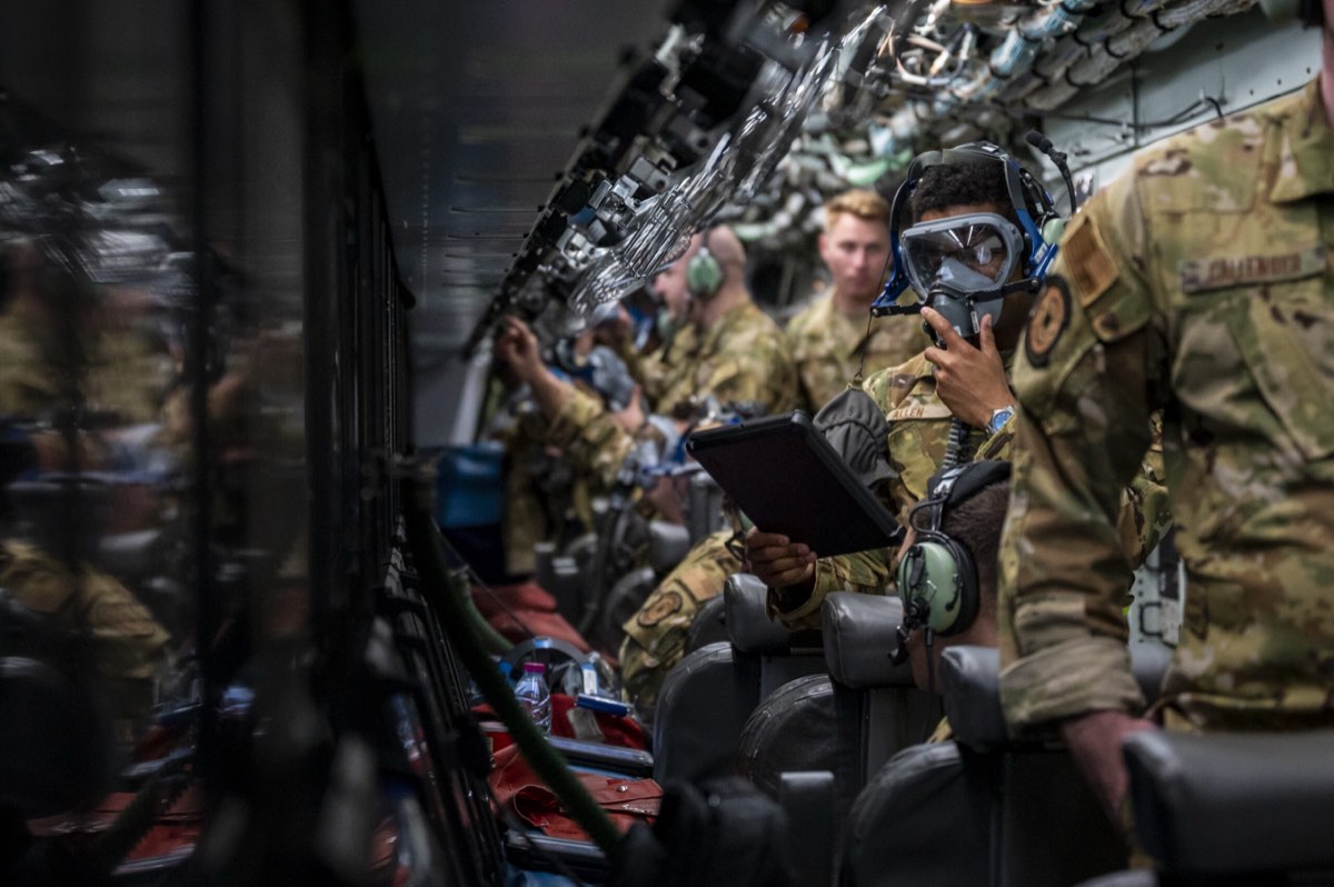 Aircrew working from a tablet aboard a military transport aircraft.