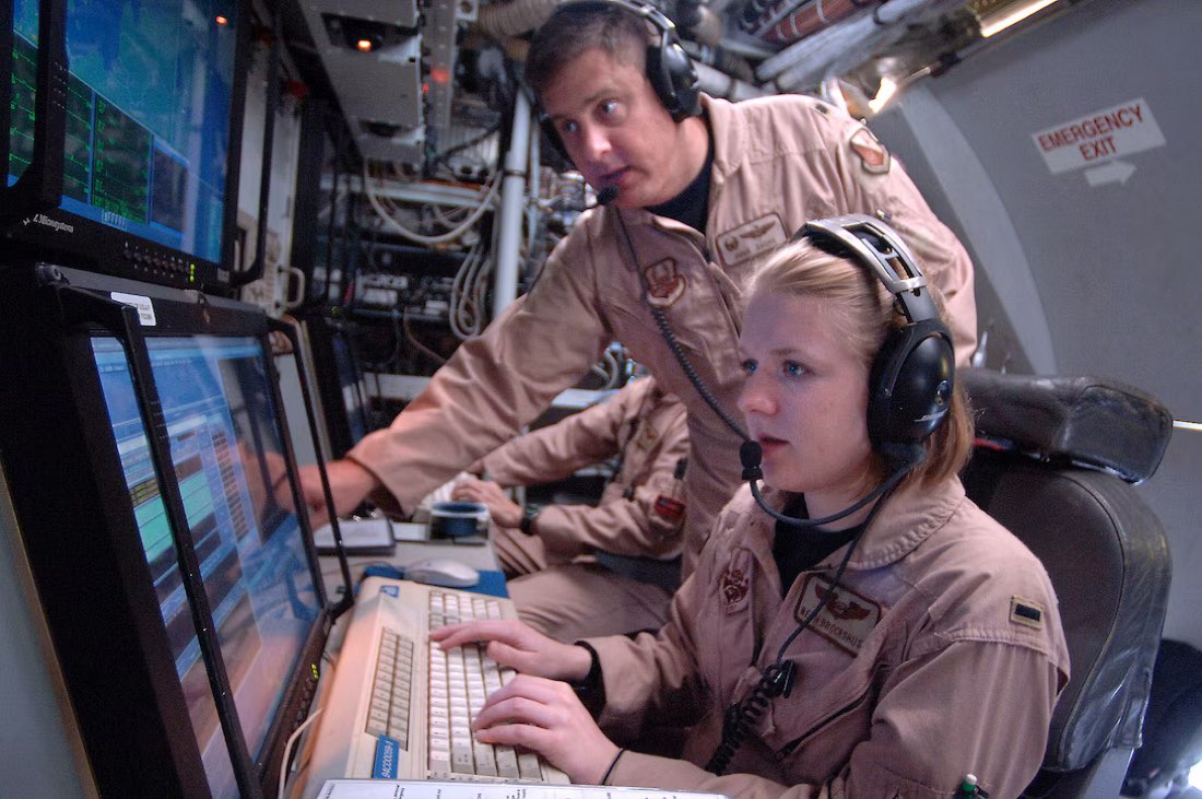 Aircrew operating mission systems consoles aboard an airborne command aircraft.